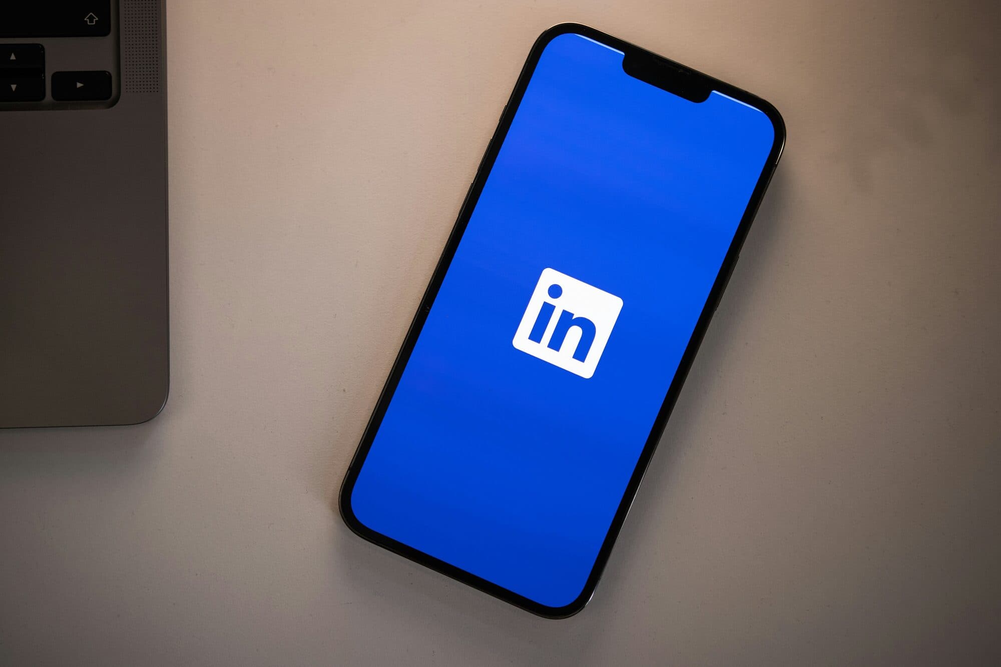 A smartphone on a desk displaying the LinkedIn logo